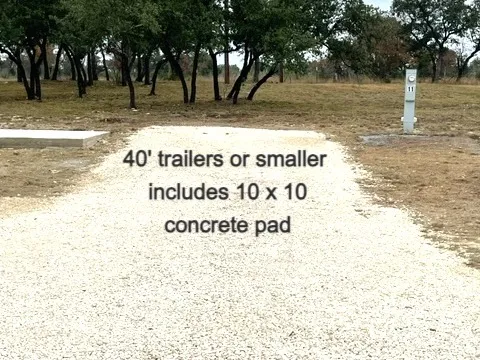 White gravel RV pad with a concrete patio at Sunset Ridge